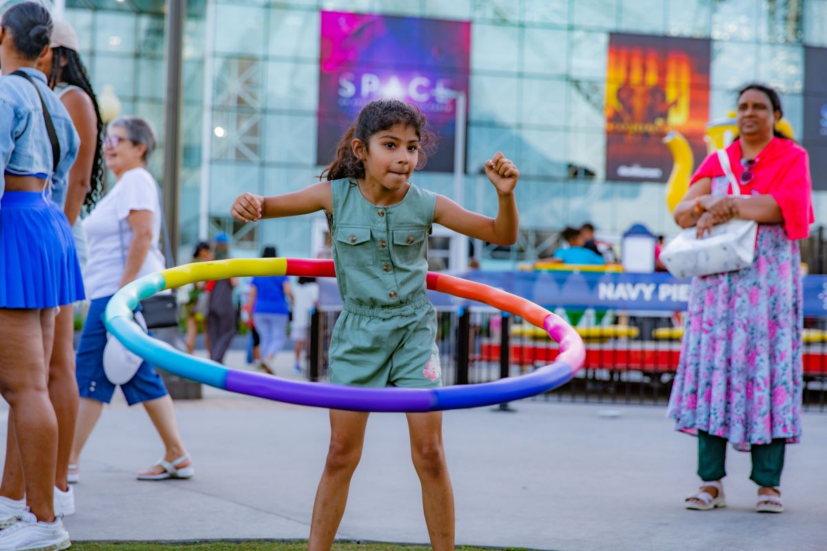 Child enjoys hula hoop activity during Navy Pier’s Summer Block Party event